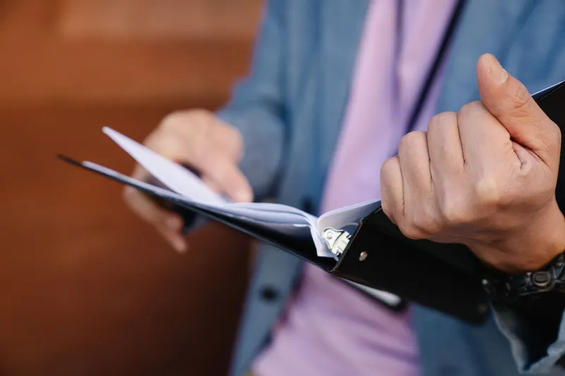 A paralegal flipping through a thick document binder